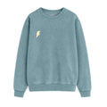 Sudadera de adulto estilo streetwear colección Roots color azul horizonte con detalle de rayo minimalista en coloramarillo pastel en el pecho de la marca Zander.