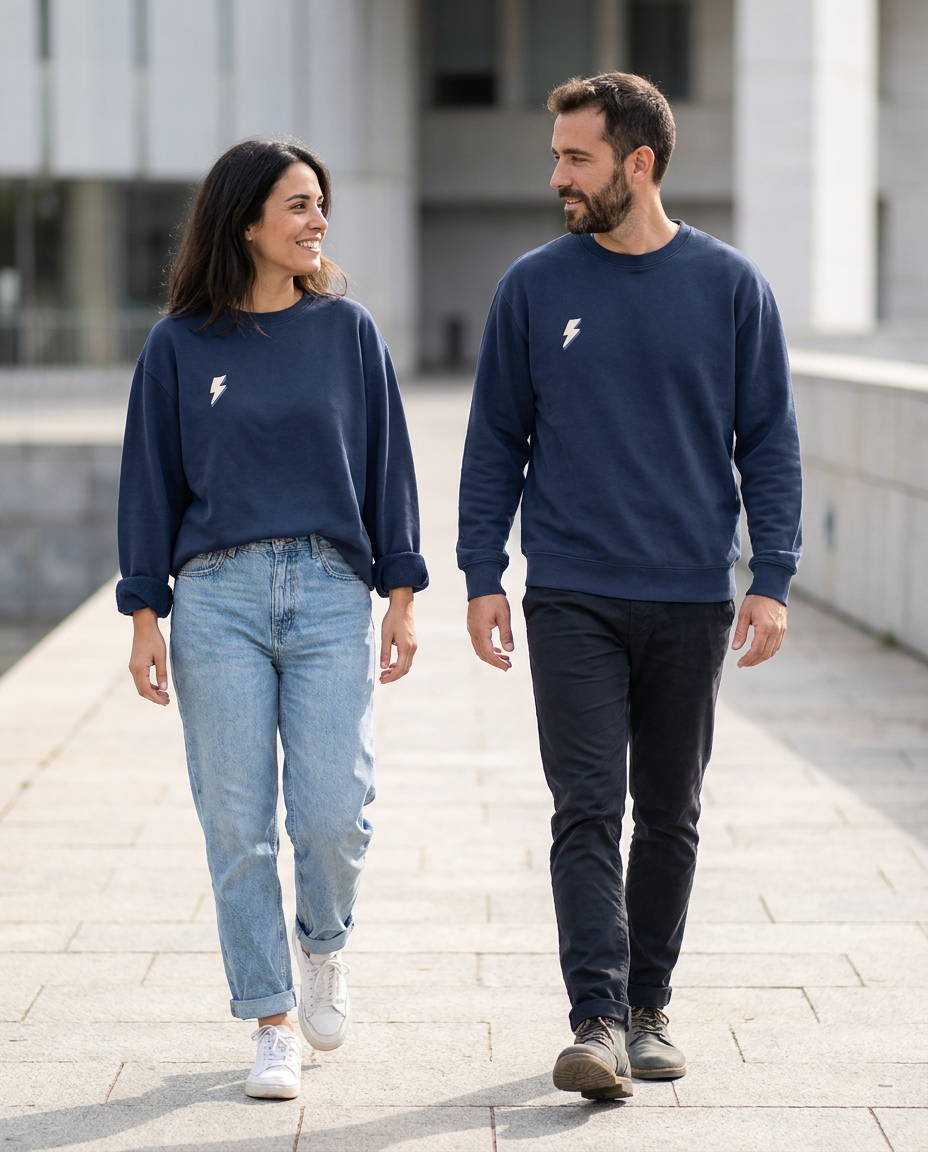 Chica y chico llevando puesta la sudadera básica azul marino con rayo minimalista en el pecho de color beig de la marca Zander.